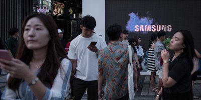 Pedestrians passing a Samsung promotional event outside a store in Seoul.